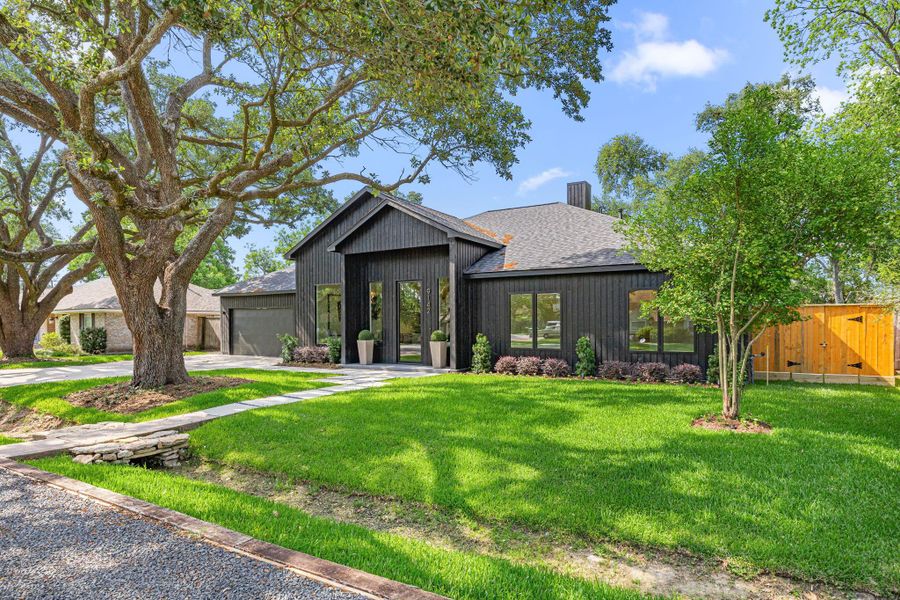 Lush designer landscaping & mature oak trees grace the front lawn.