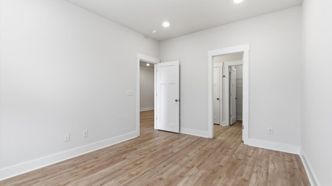 Serene and stylish primary bedroom featuring hardwood flooring and a thoughtful, modern layout at Pelham Crossing