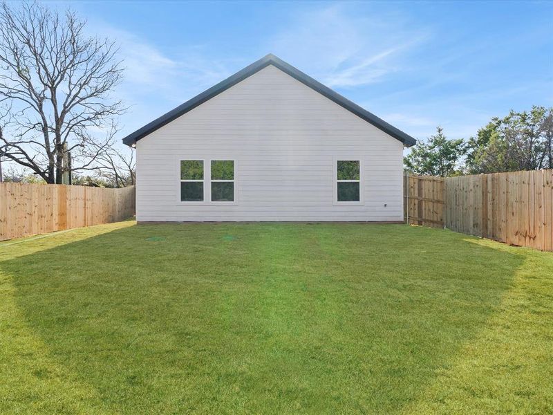 View of back of home with a fenced backyard View of back of home with a fenced backyard