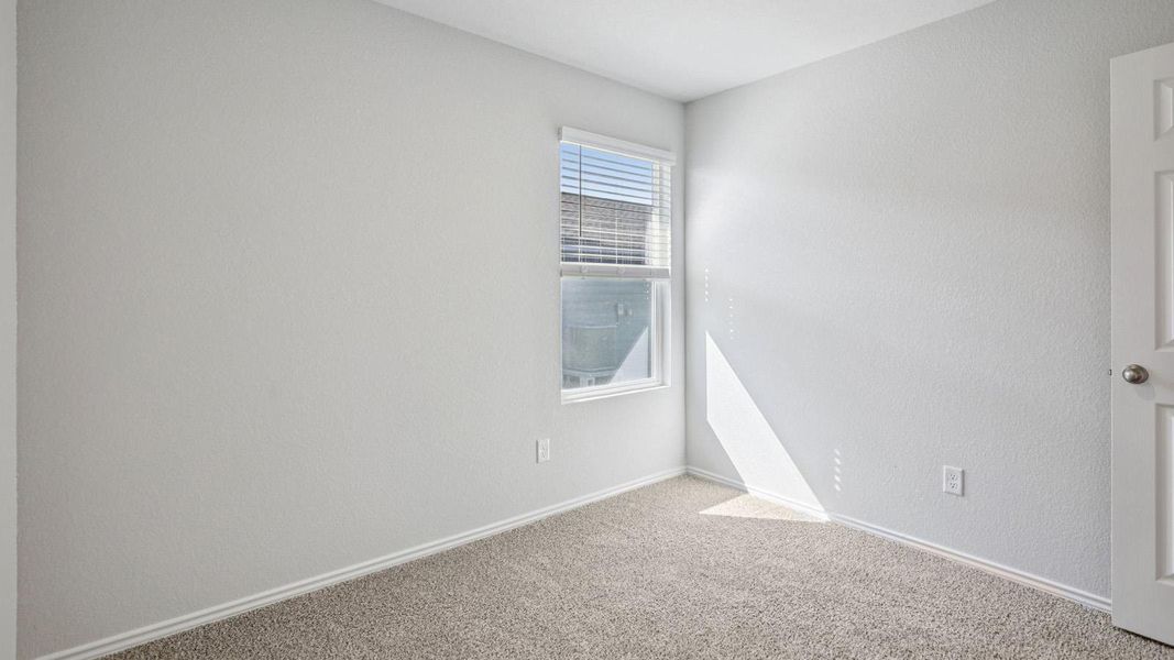 A well-lit bedroom features plush carpeting and a window allowing abundant natural light. A well-lit bedroom features plush carpeting and a window allowing abundant natural light.