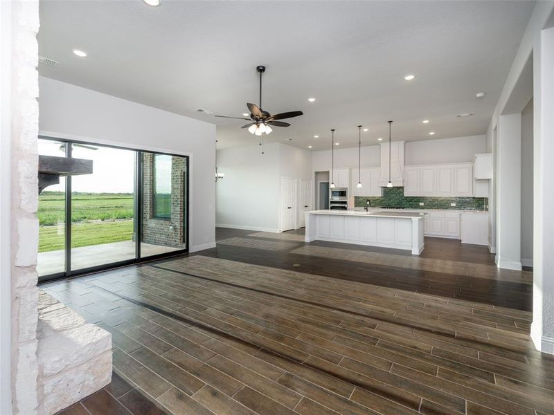 Kitchen featuring tasteful backsplash, white cabinetry, recessed lighting, open floor plan, and decorative light fixtures