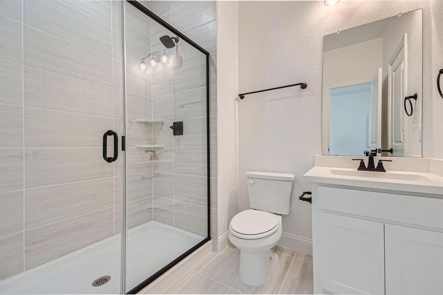 Bathroom featuring a glass-enclosed shower with matte black fixtures, light-toned rectangular wall tiling, and a white shower pan Bathroom featuring a glass-enclosed shower with matte black fixtures, light-toned rectangular wall tiling, and a white shower pan
