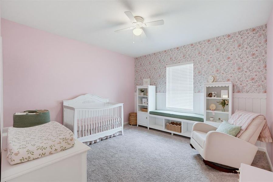 Spacious interior featuring a built-in window bench with storage, decorative wainscoting, and patterned accent wall