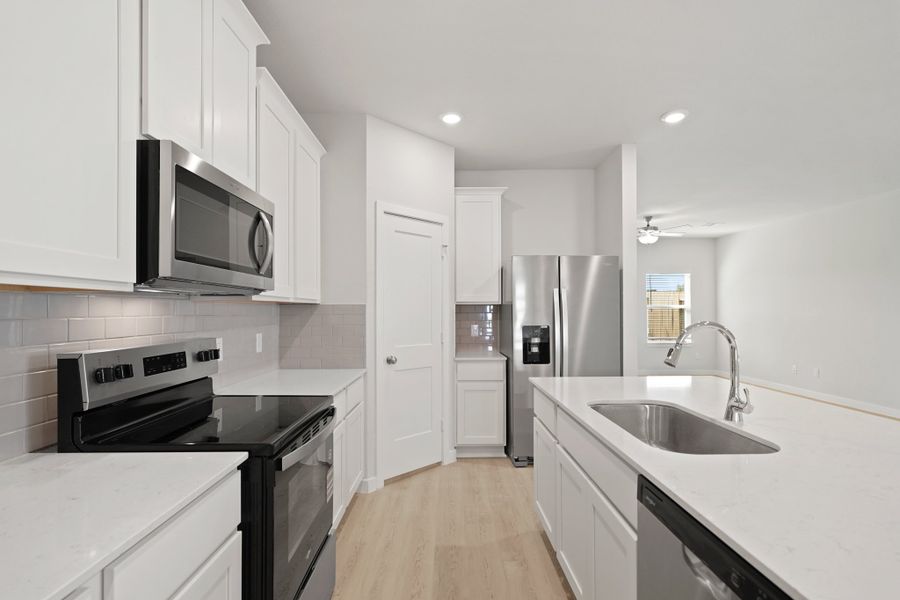 A kitchen with white cabinets.