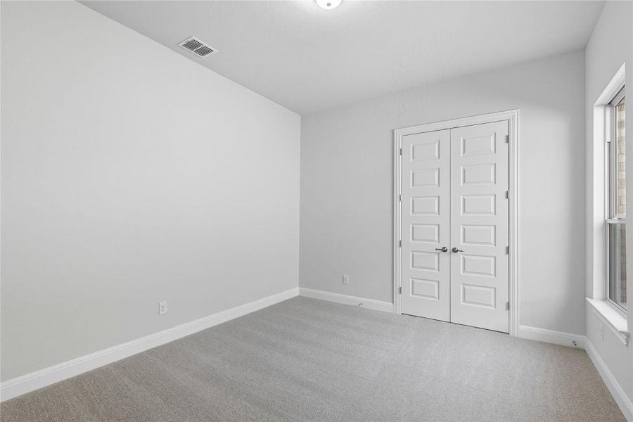 Unfurnished bedroom with light colored carpet and a closet Unfurnished bedroom with light colored carpet and a closet
