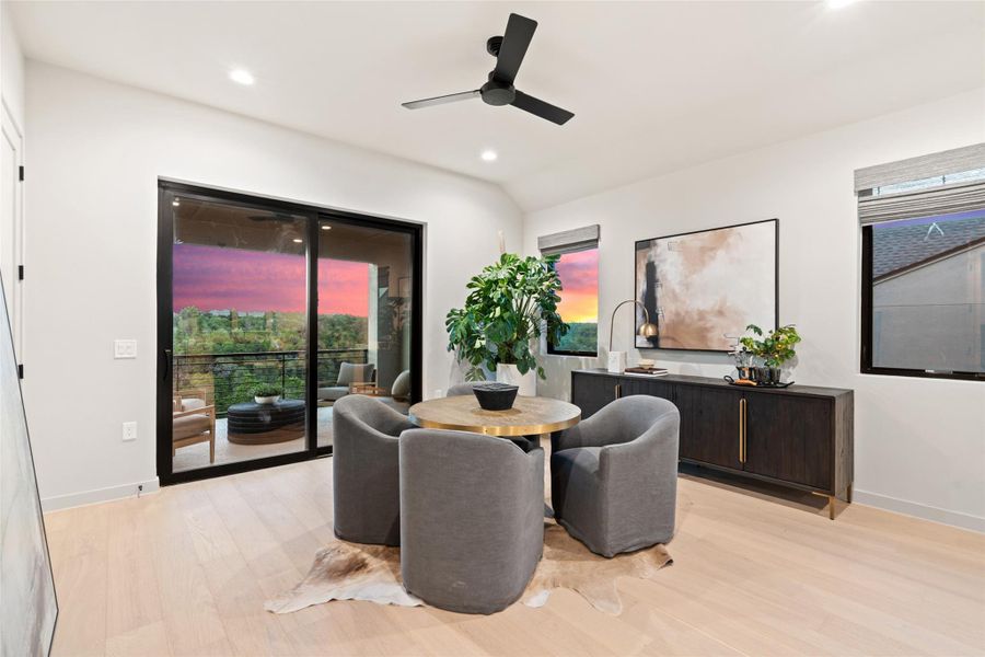 Blonde hardwood flooring complements a captivating sunset view from this room's balcony. Blonde hardwood flooring complements a captivating sunset view from this room's balcony.