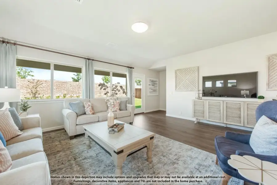 Living room with hardwood floors, large windows, neutral sofas, and a media console with wall-mounted TV