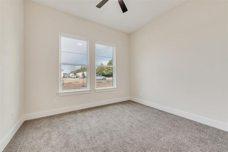 Spare room featuring light carpet and ceiling fan