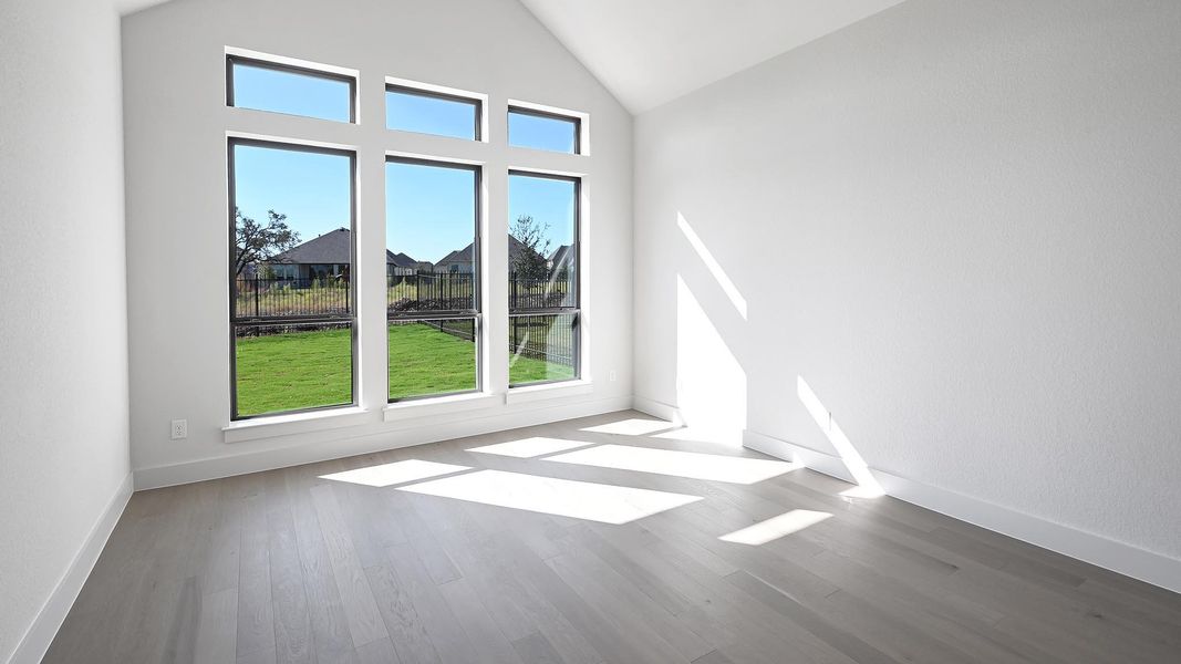 Unfurnished living room featuring vaulted ceiling and wood finished floors Unfurnished living room featuring vaulted ceiling and wood finished floors
