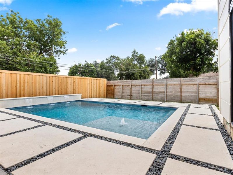 View of swimming pool with a patio area and pool water feature