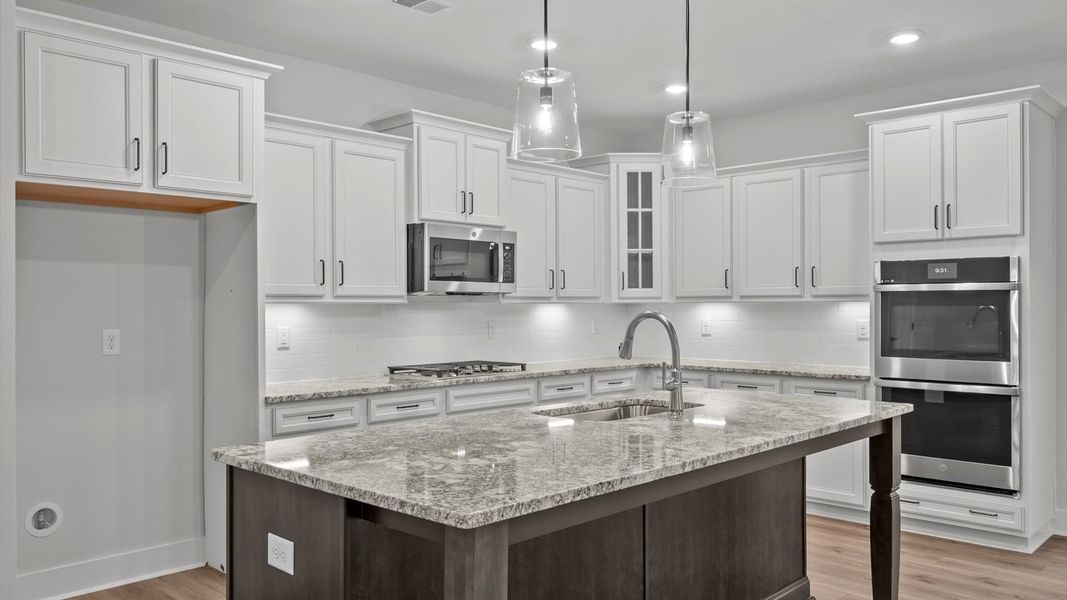 Accomplished kitchen design featuring pendant lighting above a statement island for both prep and gathering