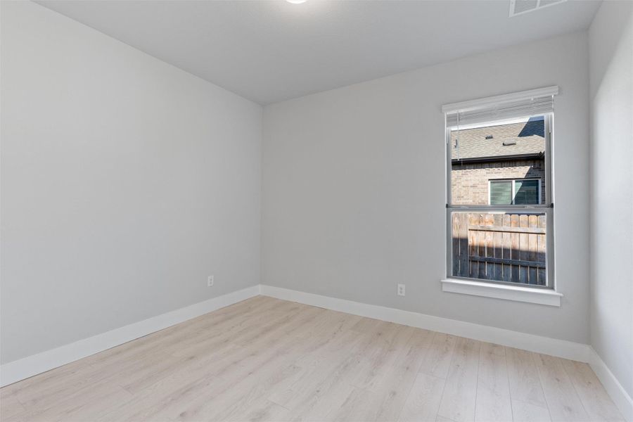 Empty room with baseboards and light wood-style flooring