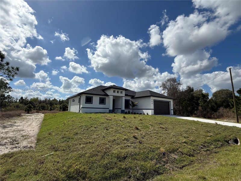 Front exterior of a new home in , Lehigh Acres, FL, highlighting curb appeal (Image 15).