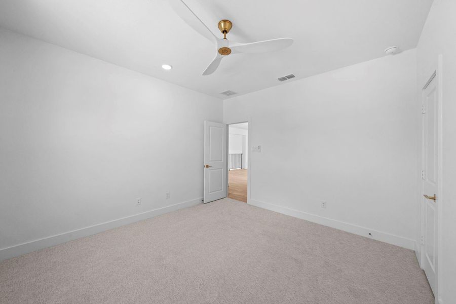 Bright secondary bedroom offering generous space and a peaceful atmosphere.