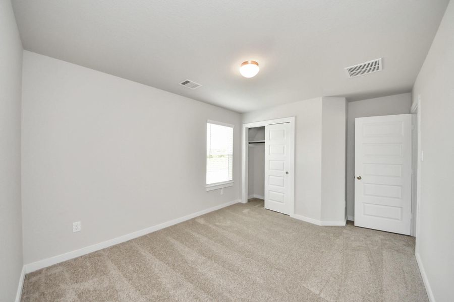 Generously sized secondary bedrooms featuring spacious closets, soft and inviting carpeting underfoot, large windows allowing plenty of natural light, and the added touch of privacy blinds for your personal retreat. Sample photo of completed home with similar floor plan. Actual colors and selections may vary. Generously sized secondary bedrooms featuring spacious closets, soft and inviting carpeting underfoot, large windows allowing plenty of natural light, and the added touch of privacy blinds for your personal retreat. Sample photo of completed home with similar floor plan. Actual colors and selections may vary.