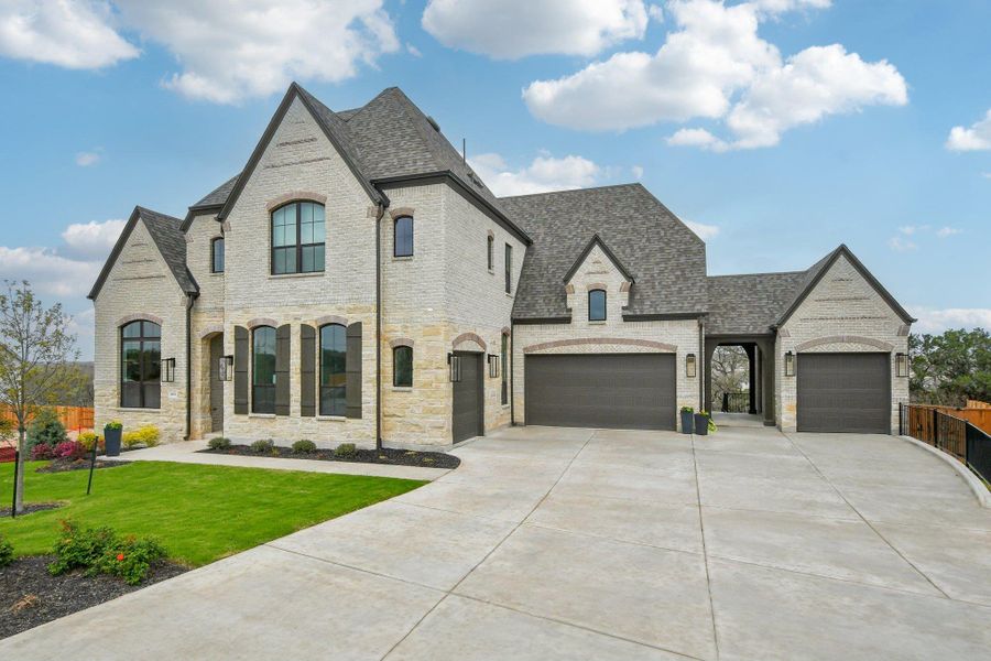 The property features a light-colored brick and stone exterior with dark trim and a multi-gabled roof The property features a light-colored brick and stone exterior with dark trim and a multi-gabled roof