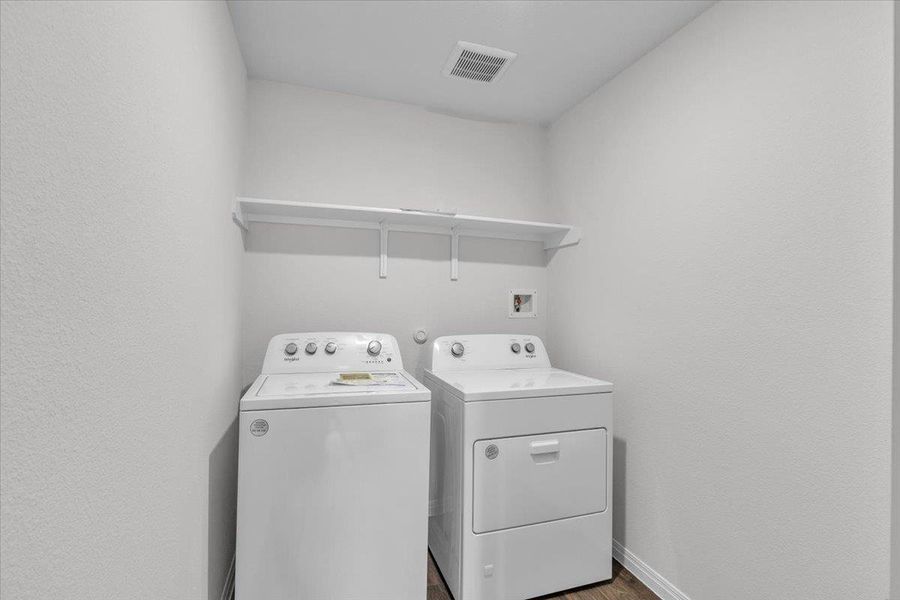 Laundry area with wood finished floors and independent washer and dryer