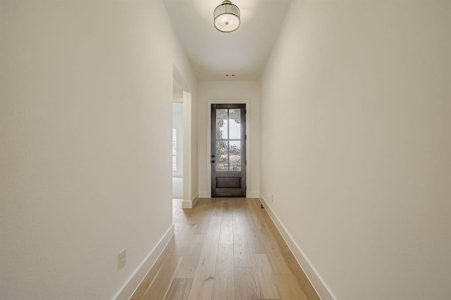 Entryway featuring hardwood / wood-style flooring and baseboards Entryway featuring hardwood / wood-style flooring and baseboards