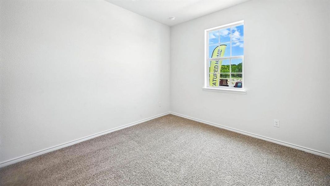 Neutral color palette room featuring light-colored carpet, white walls, and a single window with white trim