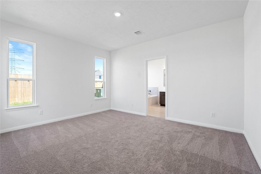 Unwind in your private sanctuary. This tranquil primary suite is a true retreat, offering a sense of calm and luxury. With plush carpeting, walk-in closet, and en-suite bath, it's the perfect place to start and end your day.