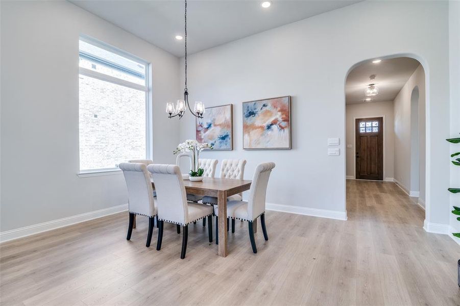 Dining space featuring light hardwood / wood-style floors and a notable chandelier