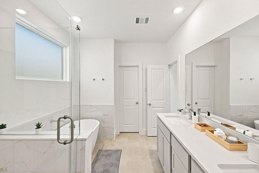 Beautiful primary bath combining a modern double vanity, soaking tub, separate shower, and contemporary finishes. Beautiful primary bath combining a modern double vanity, soaking tub, separate shower, and contemporary finishes.