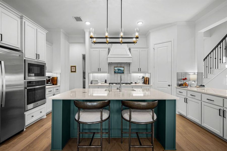 The kitchen island features a breakfast bar and upgraded lighting. The kitchen island features a breakfast bar and upgraded lighting.