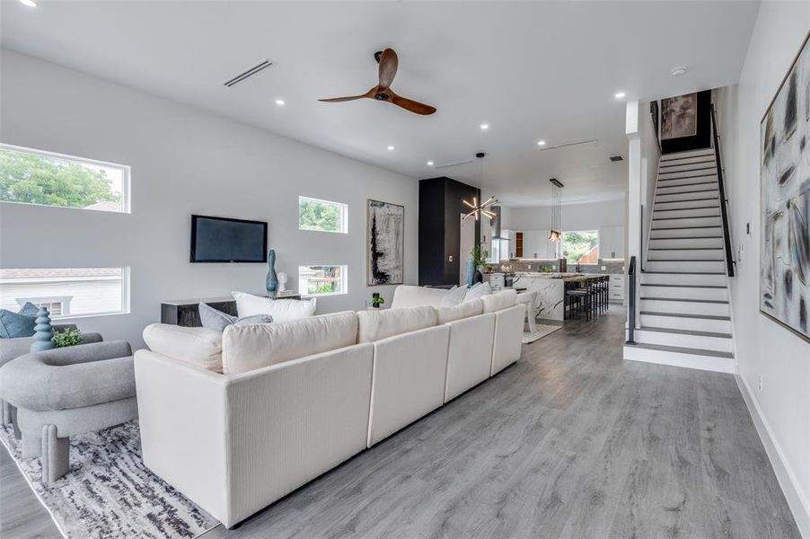 Living room featuring a wealth of natural light, ceiling fan, and light wood-type flooring