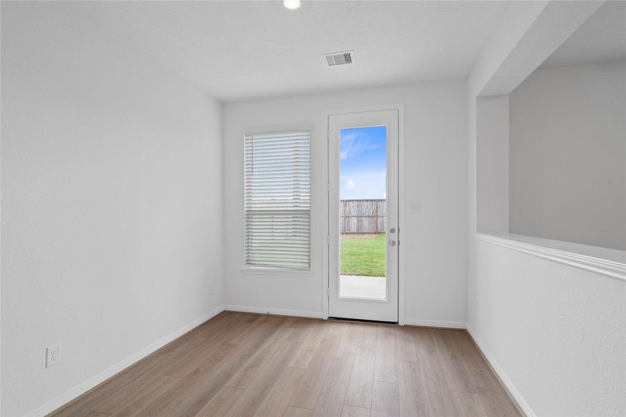 Start your day with a warm cup of coffee and quality time in this charming nook! Highlights include a large window, custom neutral paint, vinyl plank flooring, recessed lighting, high ceilings, and a convenient door leading to the rear patio and backyard.