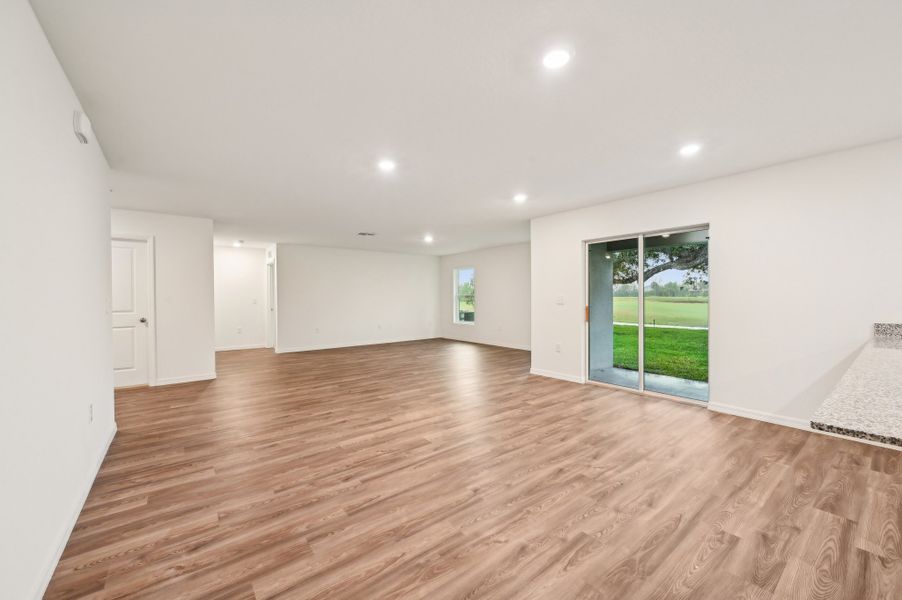 A large empty room with a wood floor and a large window.