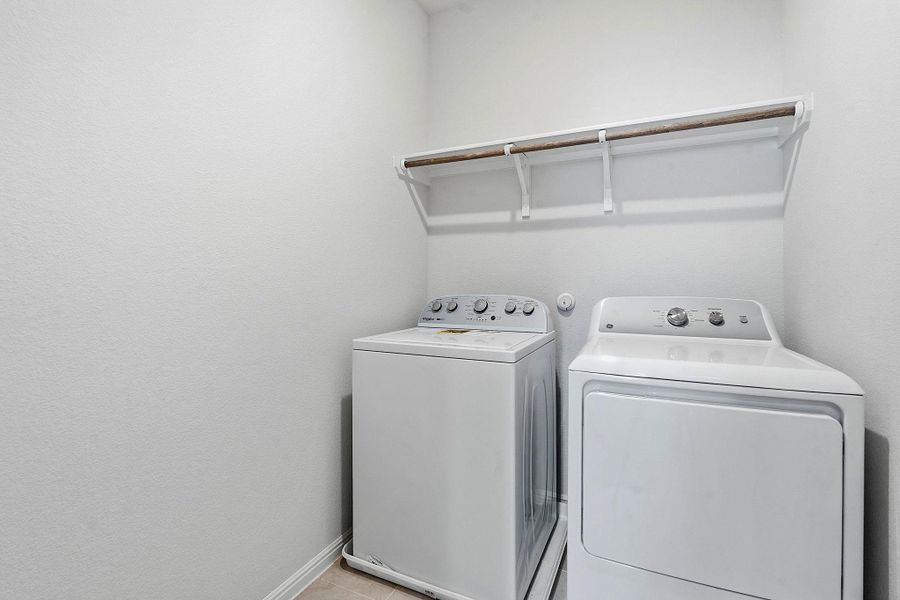A well-organized laundry area offers a convenient washer and dryer set with a practical overhead shelf. A well-organized laundry area offers a convenient washer and dryer set with a practical overhead shelf.