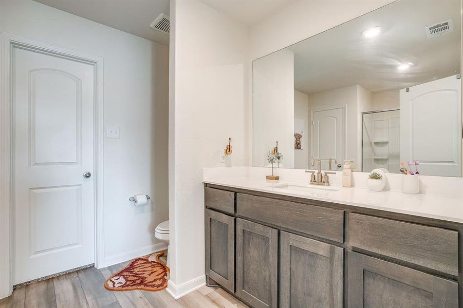Full bathroom featuring vanity, light wood finished floors, and an enclosed shower