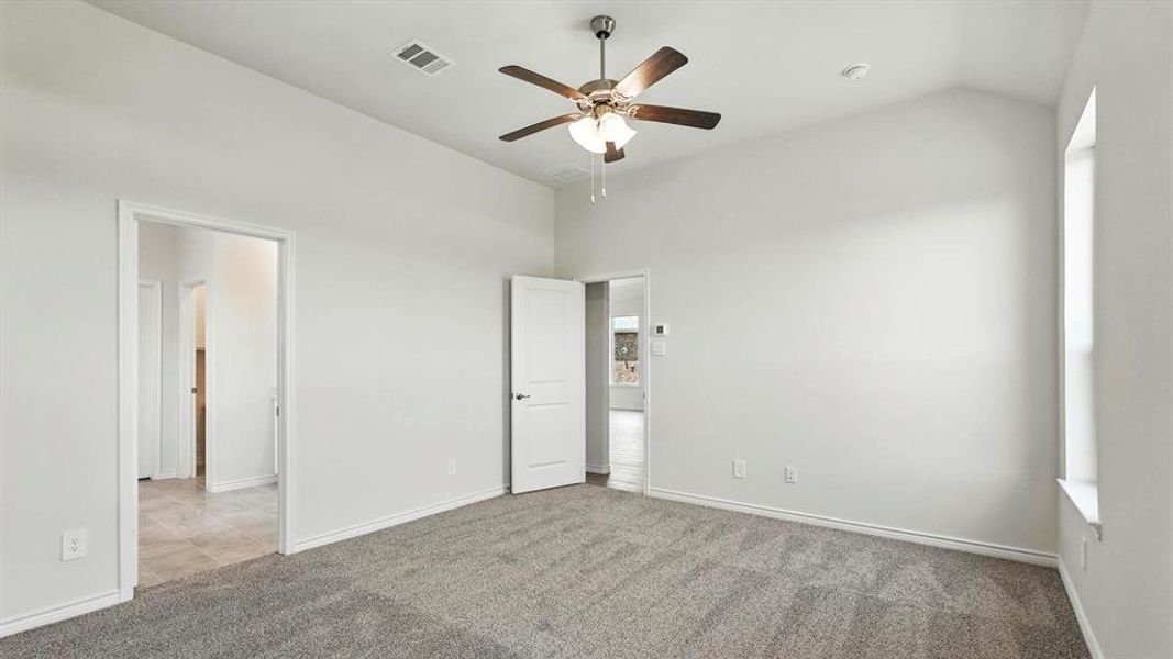 Spacious interior room featuring vaulted ceilings and neutral gray carpeting Spacious interior room featuring vaulted ceilings and neutral gray carpeting