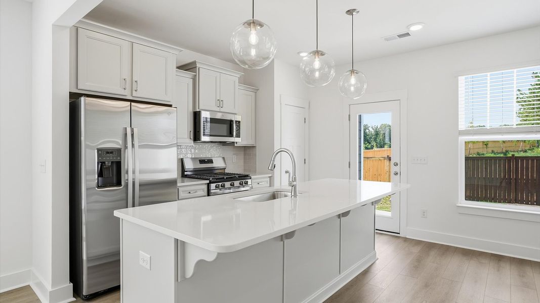 Superior craftsmanship shines in this modern kitchen with a space-saving island and open flow at Barton Hollow