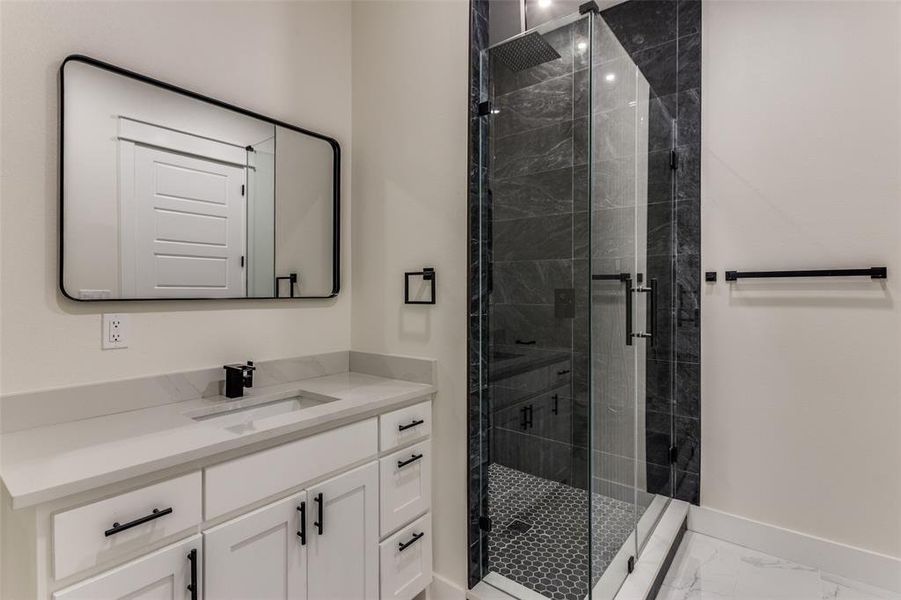 Full bath with baseboards, vanity, marble finish floor, and a shower stall