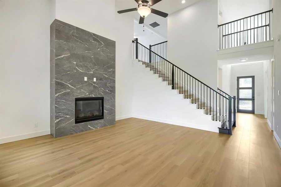 Two-story interior featuring a grand fireplace with a dark, veined stone finish Two-story interior featuring a grand fireplace with a dark, veined stone finish