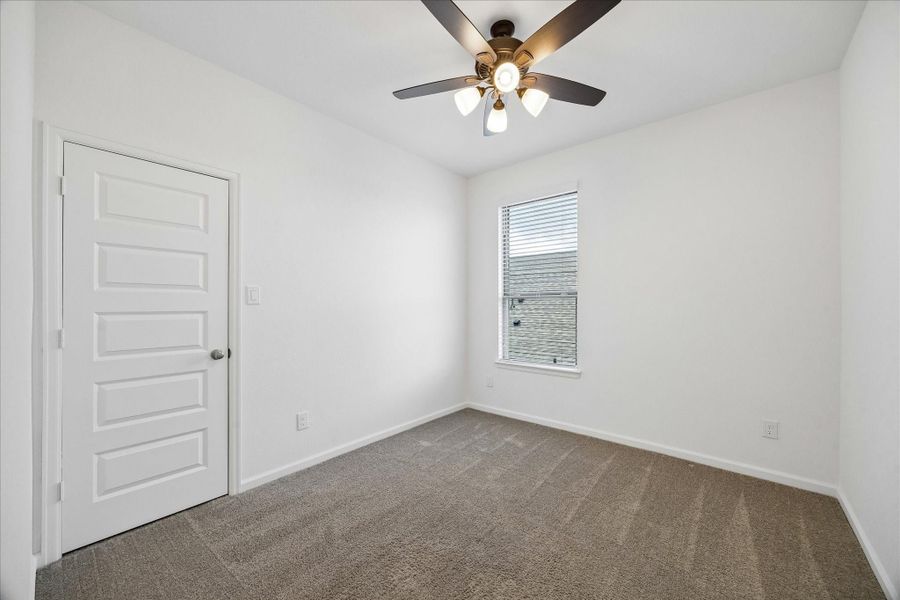 This roomy upstairs bedroom features soft neutral finishes, a cooling fan, a large walk-in closet, and easy access to the nearby full bathroom. The thoughtful floor plan offers great flexibility with a first-floor primary suite, a guest bedroom and full bath downstairs, plus two additional bedrooms and a full bath upstairs.