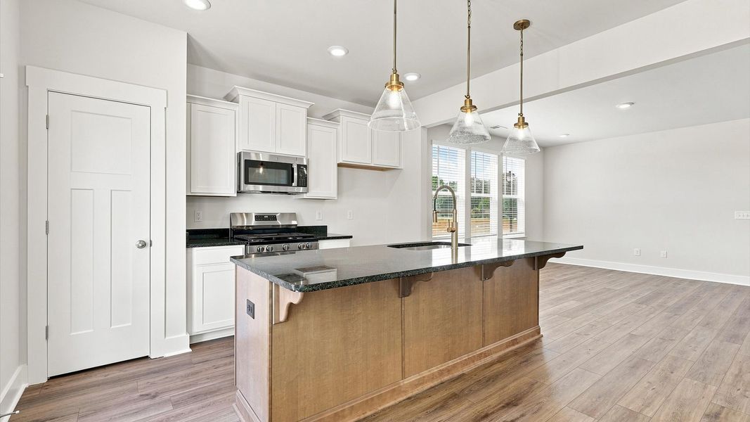 Memorable meals begin in this vibrant kitchen with pendant lighting and a thoughtfully designed island by DRB Homes Memorable meals begin in this vibrant kitchen with pendant lighting and a thoughtfully designed island by DRB Homes