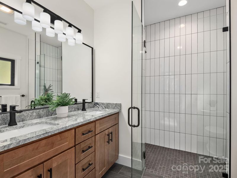 Spa-like primary bathroom with floor to ceiling tiled shower and modern finishes throughout