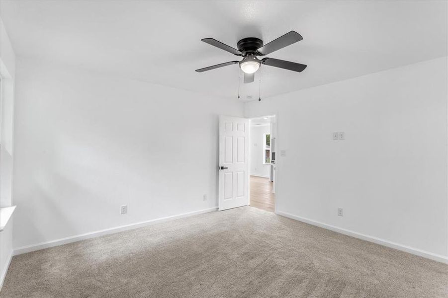 Master bedroom featuring ceiling fan and light carpet