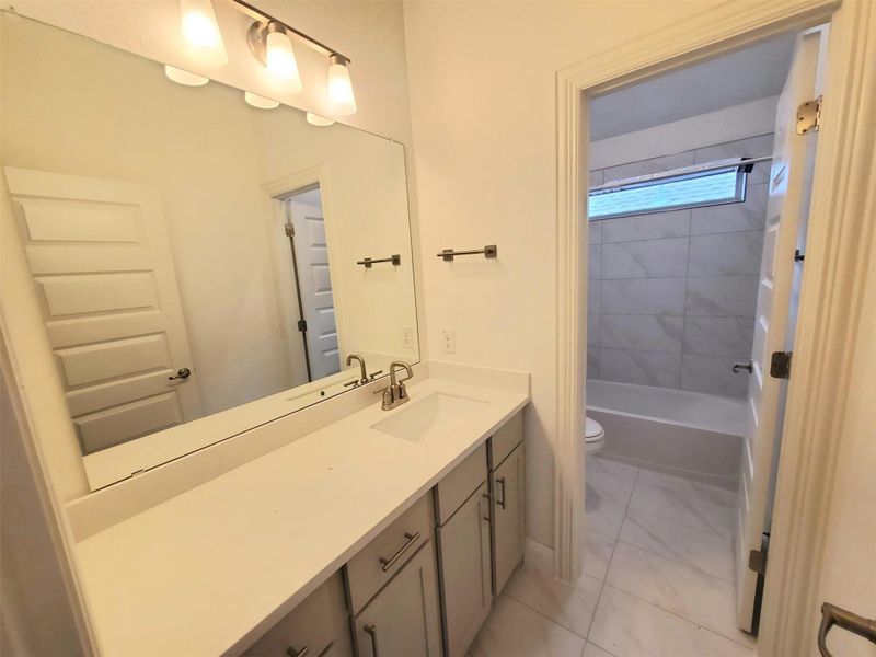 Bathroom featuring shower / bathing tub combination, marble finish floor, toilet, and vanity Bathroom featuring shower / bathing tub combination, marble finish floor, toilet, and vanity