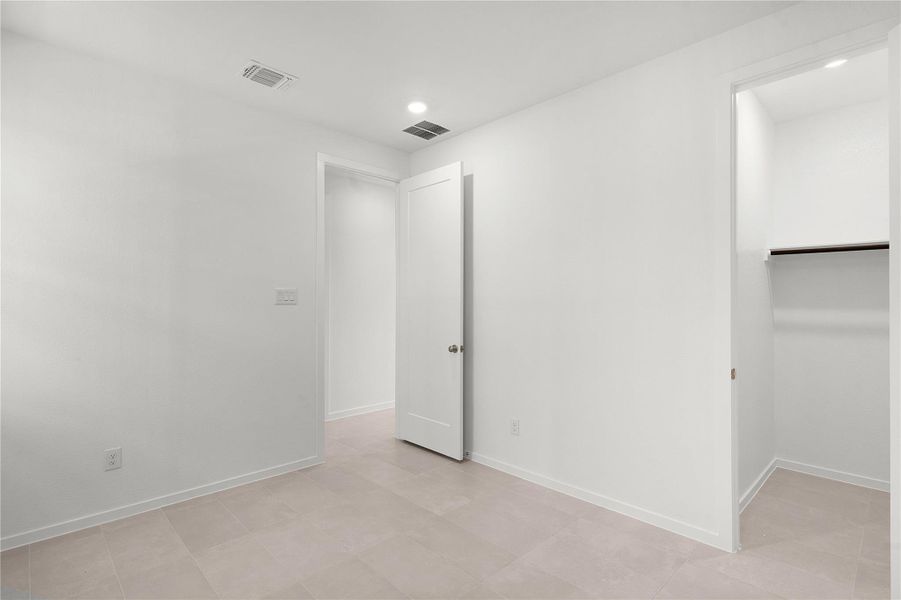 Unfurnished bedroom featuring baseboards, a walk in closet, recessed lighting, and a closet