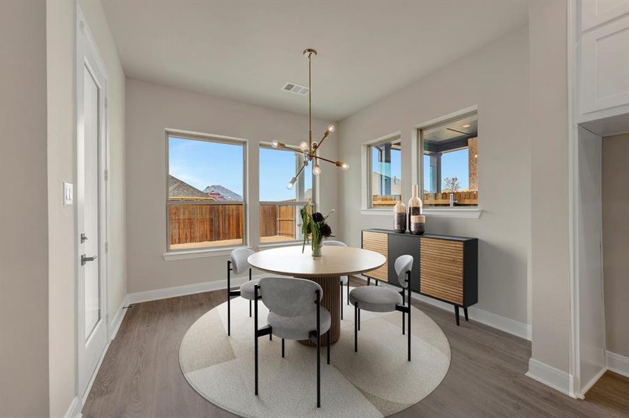 Dining space featuring wood finished floors, suspended lighting, and plenty of natural light