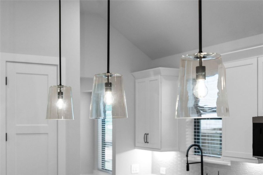 A trio of contemporary pendant lights perfectly illuminates the clean lines of the oversized gourmet prep island. A trio of contemporary pendant lights perfectly illuminates the clean lines of the oversized gourmet prep island.
