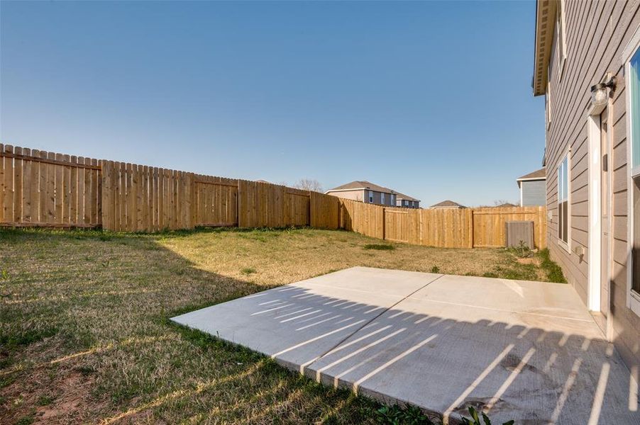 Fenced backyard with a patio