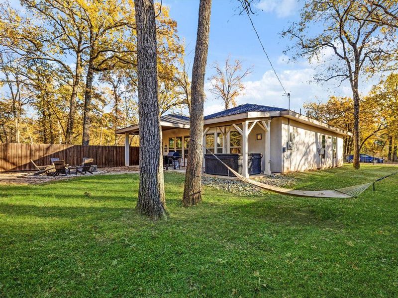 Rear view of house featuring stucco siding, a patio, and a fire pit