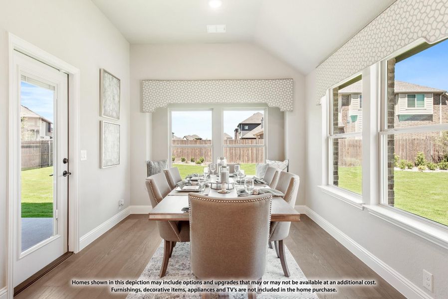 Bright dining room with vaulted ceiling, large windows, hardwood floors, and a set dining table for six. Bright dining room with vaulted ceiling, large windows, hardwood floors, and a set dining table for six.