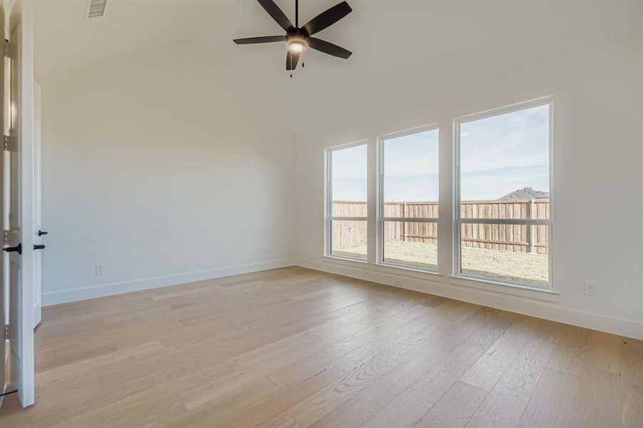Spare room featuring light wood-type flooring, high vaulted ceiling, and a ceiling fan Spare room featuring light wood-type flooring, high vaulted ceiling, and a ceiling fan