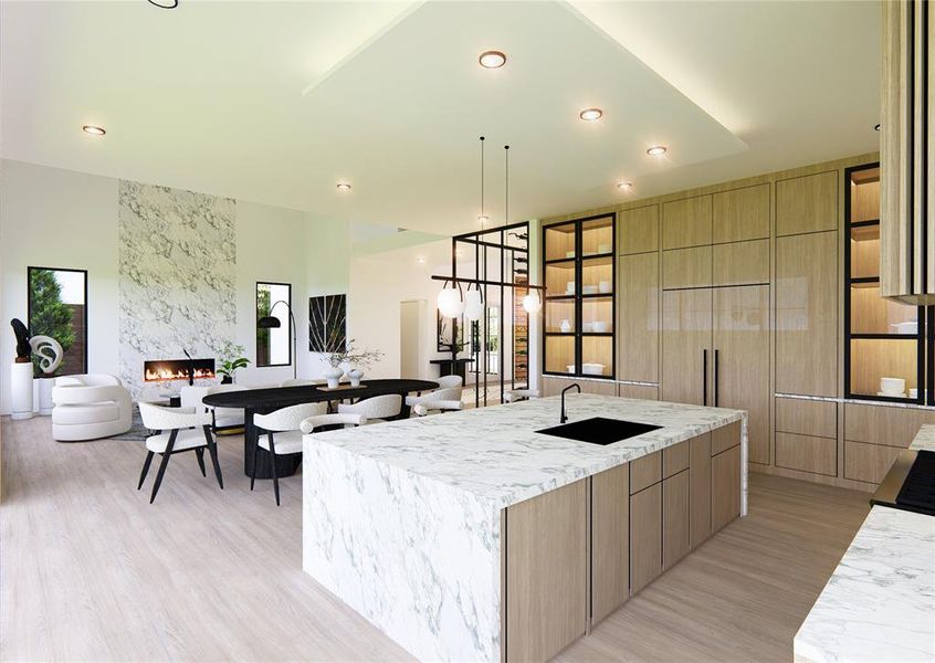 Kitchen featuring light hardwood / wood-style floors, sink, a high end fireplace, and a spacious island