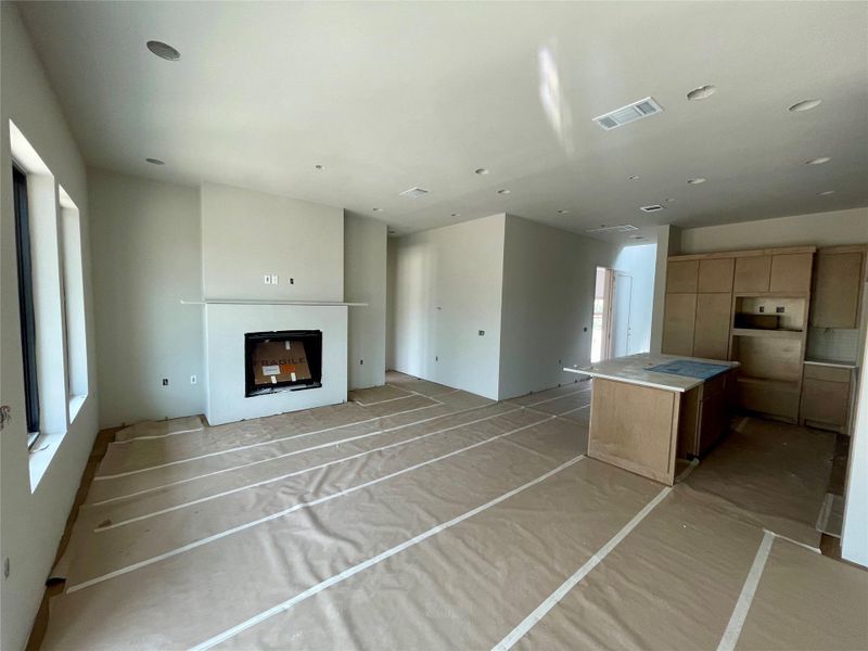 Living area featuring a fireplace with a mantel, recessed lighting, and large windows
